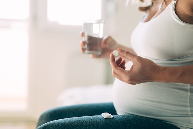 Picture of pregnant woman taking medication pills